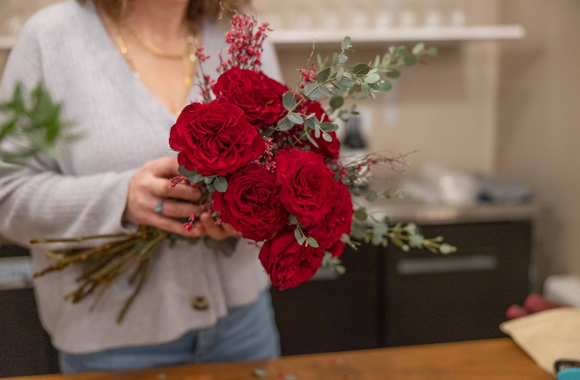 Local florist holding a bouquet of a dozen fresh red roses at Uwharrie vineyards in albemarle North Carolina 